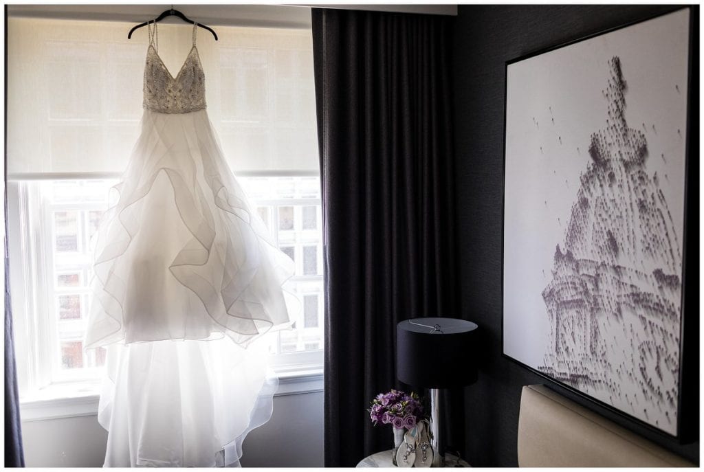 Layered ballgown wedding dress hanging in window of Le Meridien Philadelphia