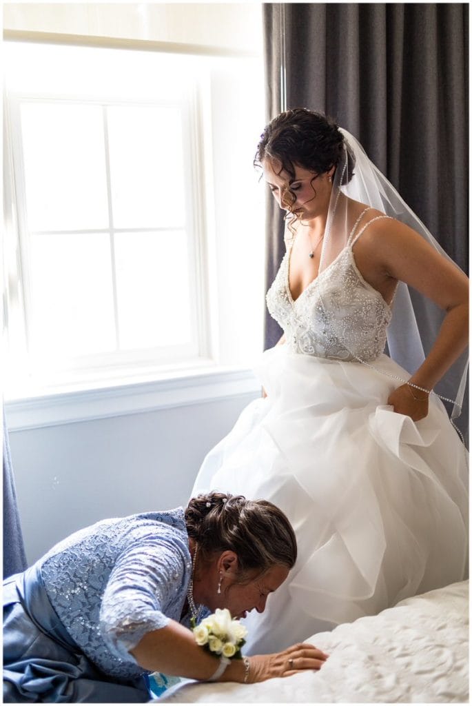 Mother of the bride helping bride into shoes at Le Meridien Philadelphia