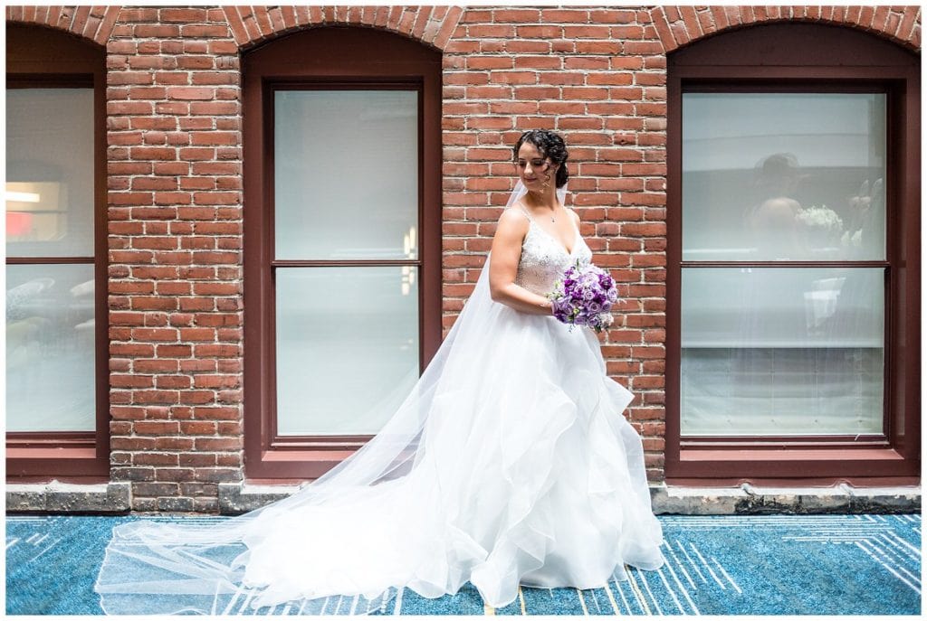 Bridal portrait with long veil and dress train in courtyard at Le Meridien Philadelphia
