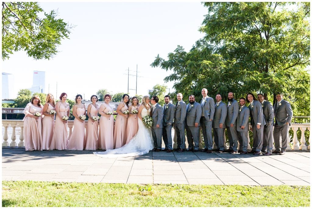 Traditional wedding party portrait with bride and groom kissing at Waterworks Philadelphia wedding reception