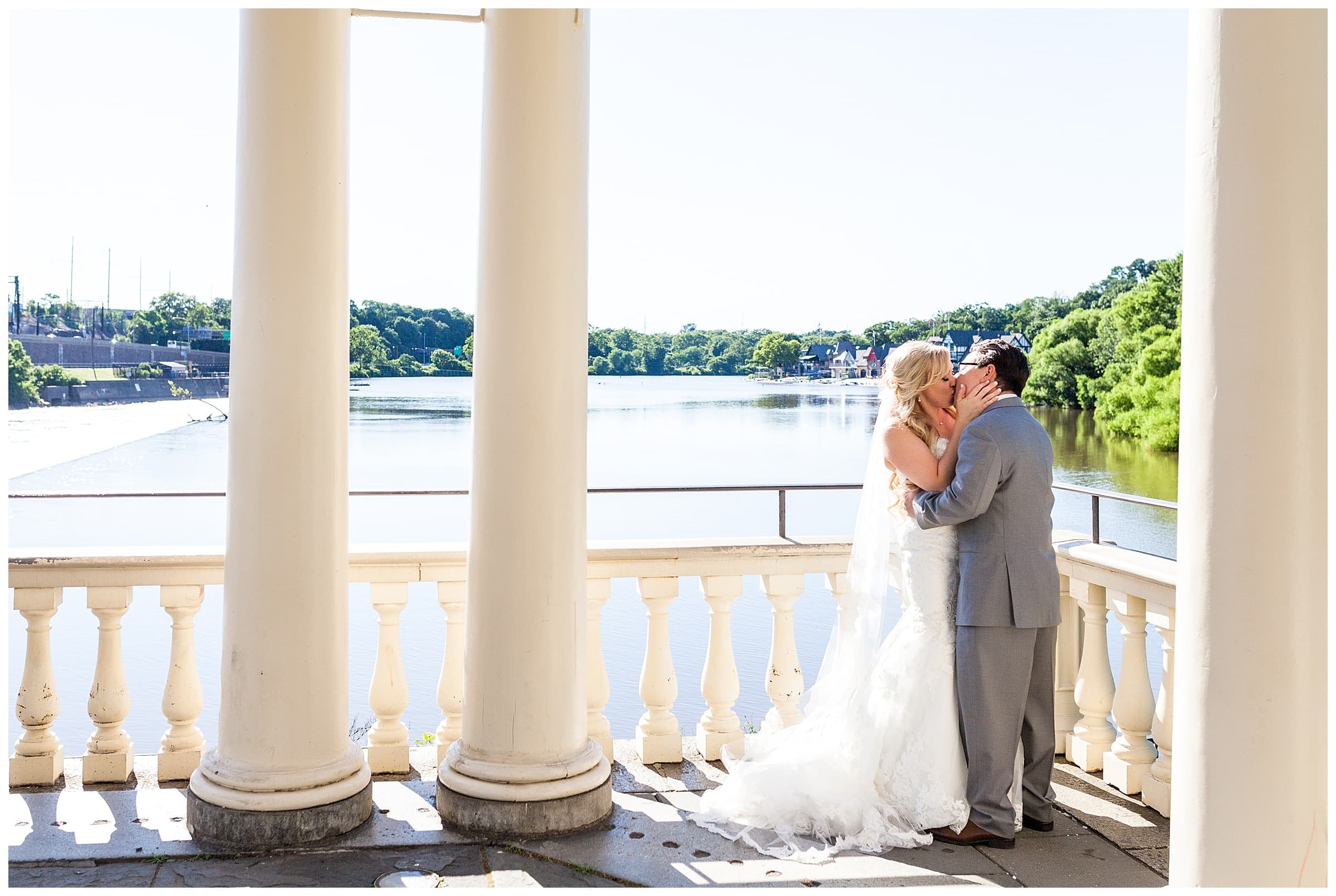 Traditional bride and groom kissing portrait in front of columns at Waterworks Philadelphia wedding reception