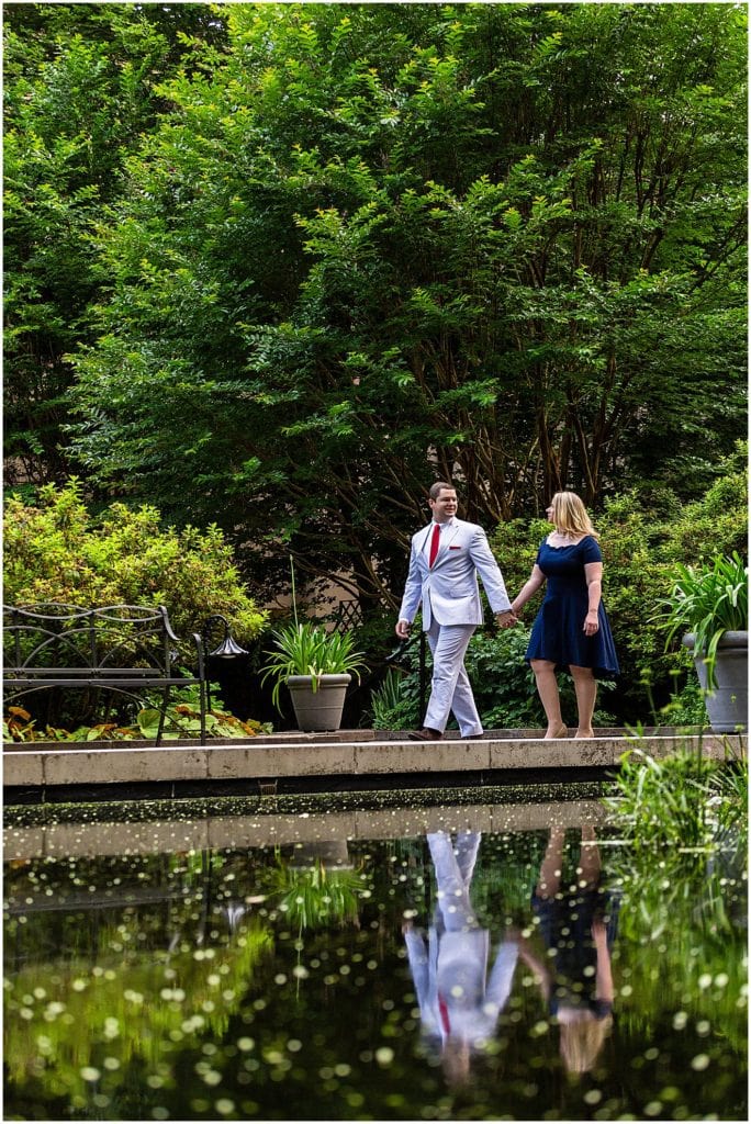 Classic engagement session portrait walking by pond with reflection at Winterthur
