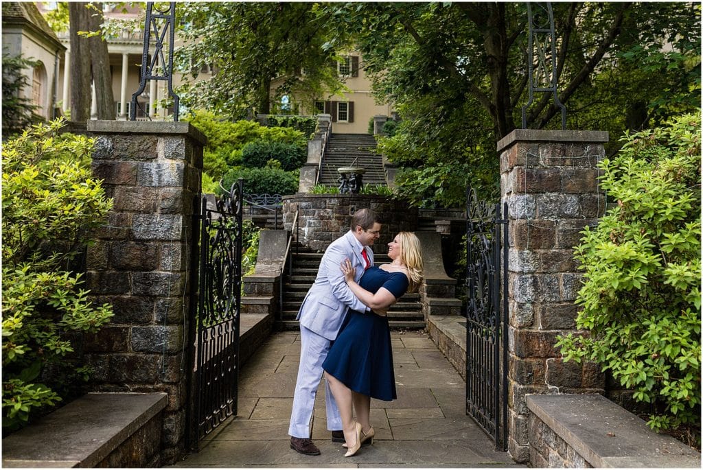 Groom dipping bride engagement portrait in gated gardens of Winterthur engagement session