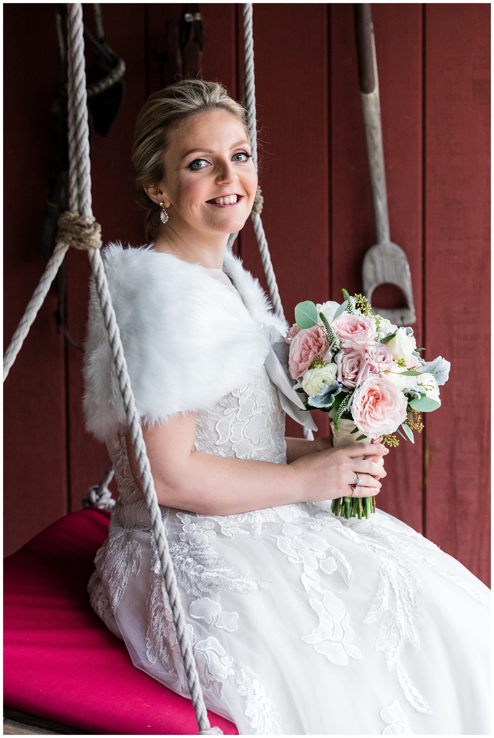 Bride sitting on swing holding pink rose bouquet portrait
