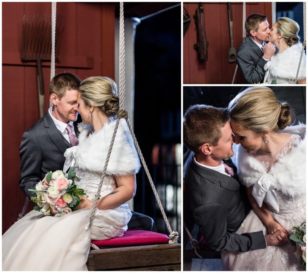 Bride and groom snuggle and kiss on swing at Barn on Bridge holiday winter wedding