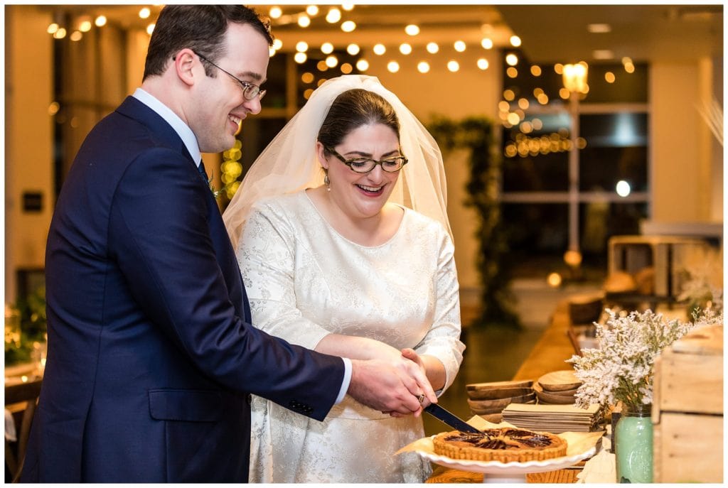 Bride and groom cut wedding pie at intimate wedding at Malvern Buttery