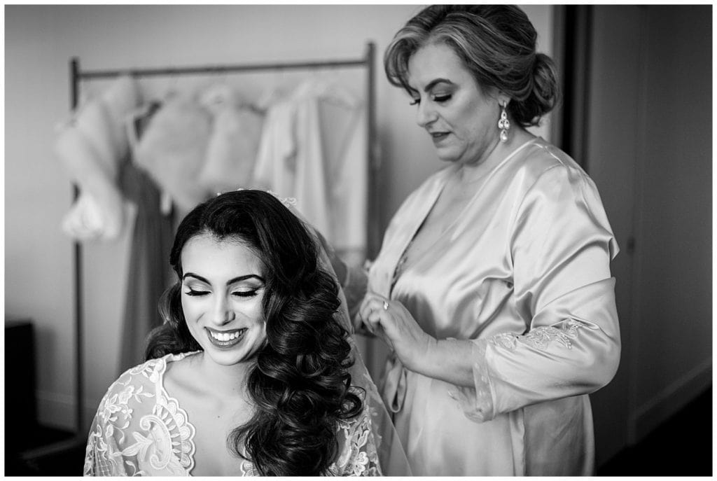 Black and white bridal portrait with mother of the bride pinning on veil