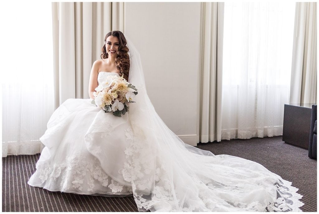 Traditional window lit bridal portrait with long veil and bouquet