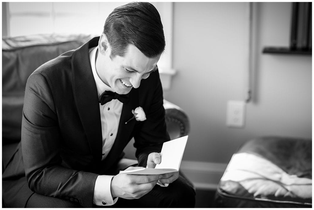 Black and white portrait of groom reading letter from bride