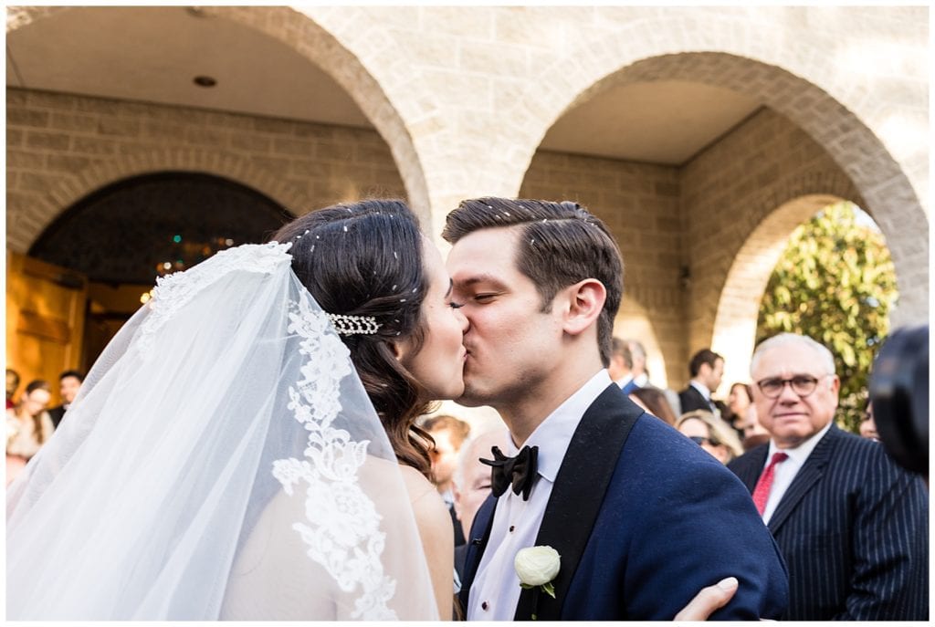 Bride and groom kiss after exiting church