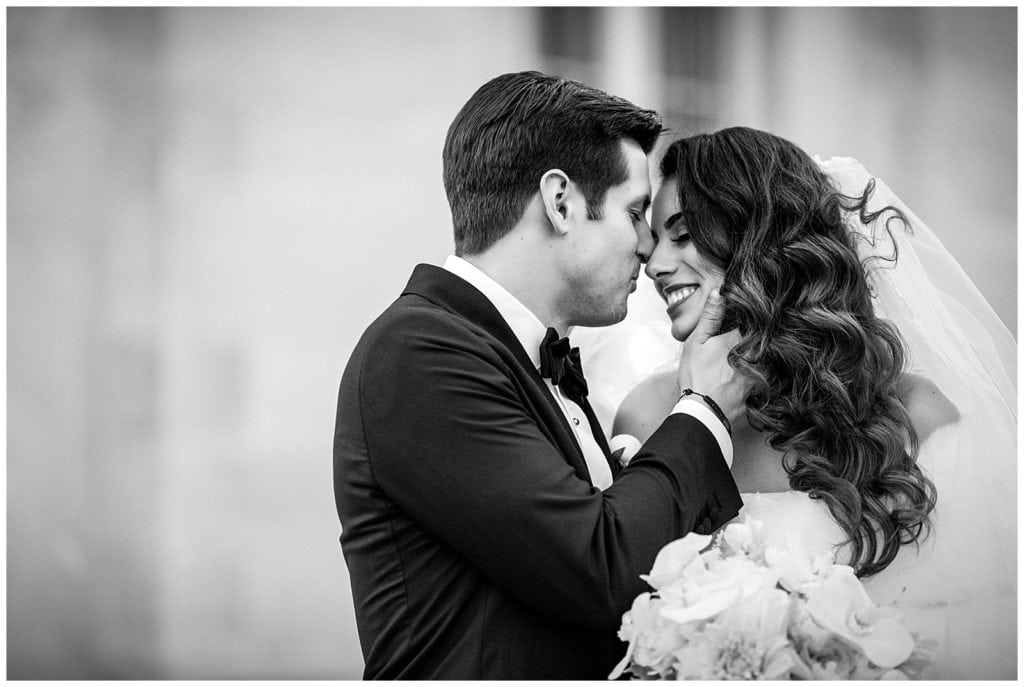 Black and white portrait of bride and groom about to kiss