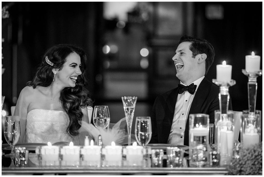 Black and white portrait of bride and groom laughing during speeches at Crystal Tea Room wedding reception