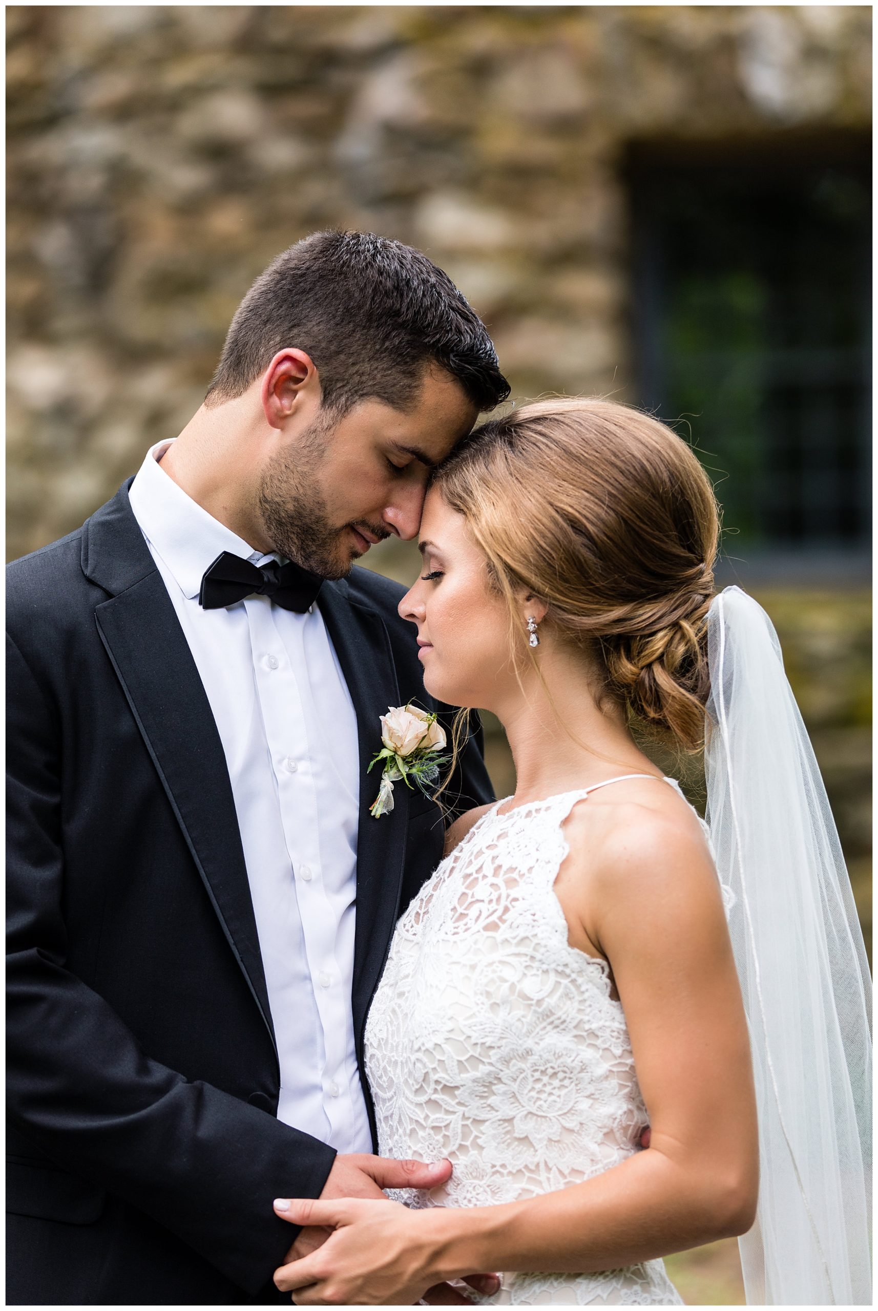 Bride and groom snuggle and touch forehead portrait at the Olde Mill Inn wedding