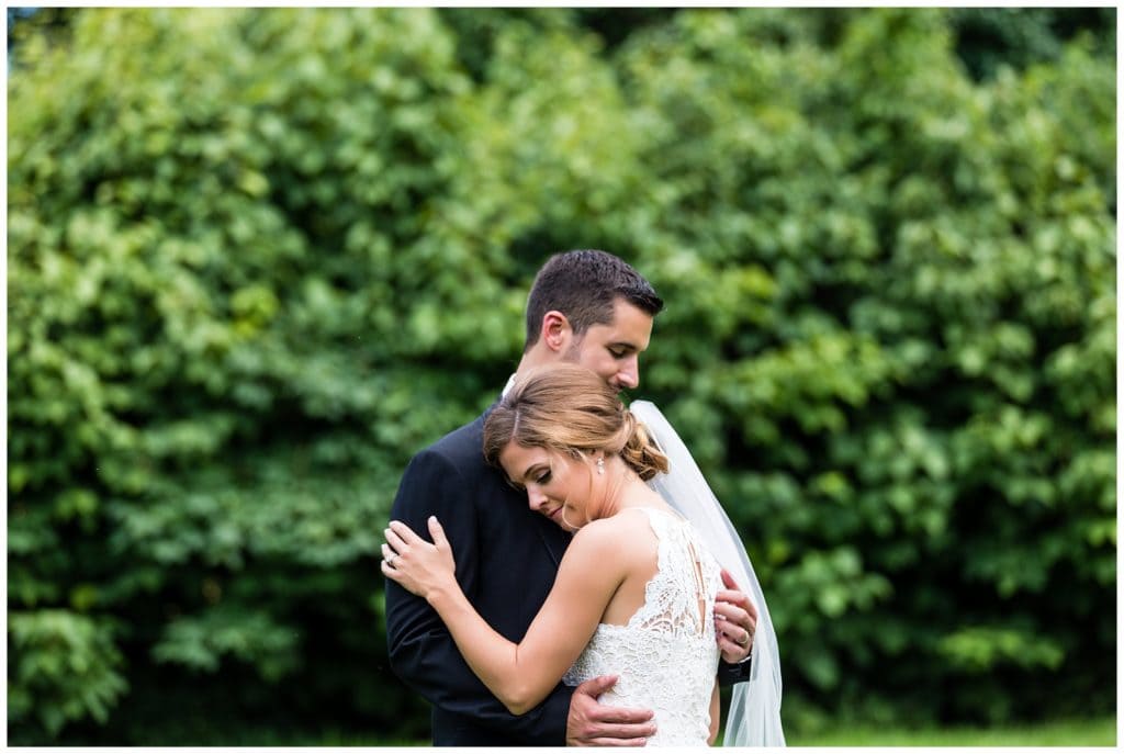 Romantic wedding portrait of bride and groom hugging in garden at the Olde Mill Inn