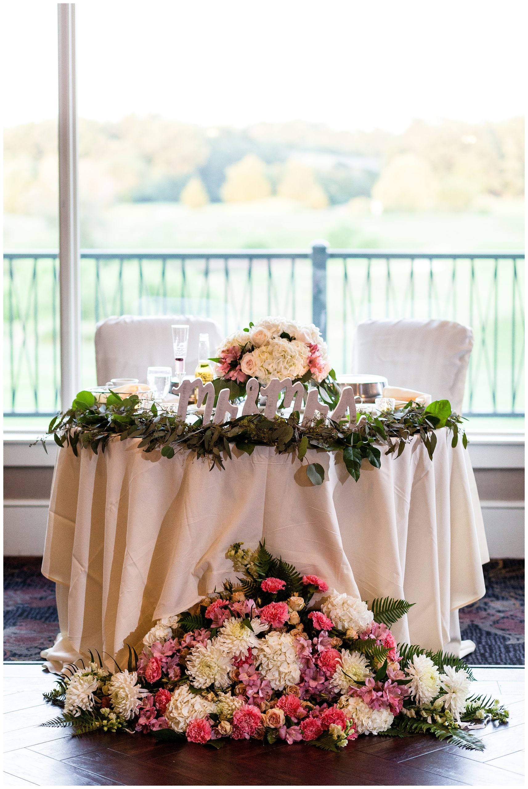 Sweetheart table with mr and mrs sign and large floral detail at Scotland Run wedding reception