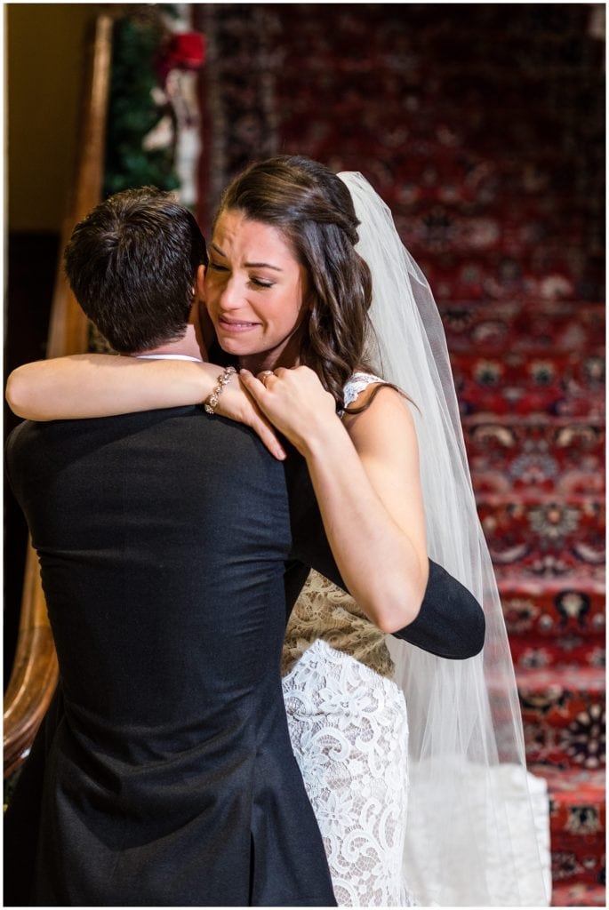 Bride and groom hug and cry during first look at Racquet Club of Philadelphia winter holiday wedding