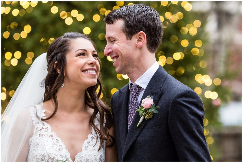 Bride and groom smile at each other in Rittenhouse Square Park with bokeh tree lights