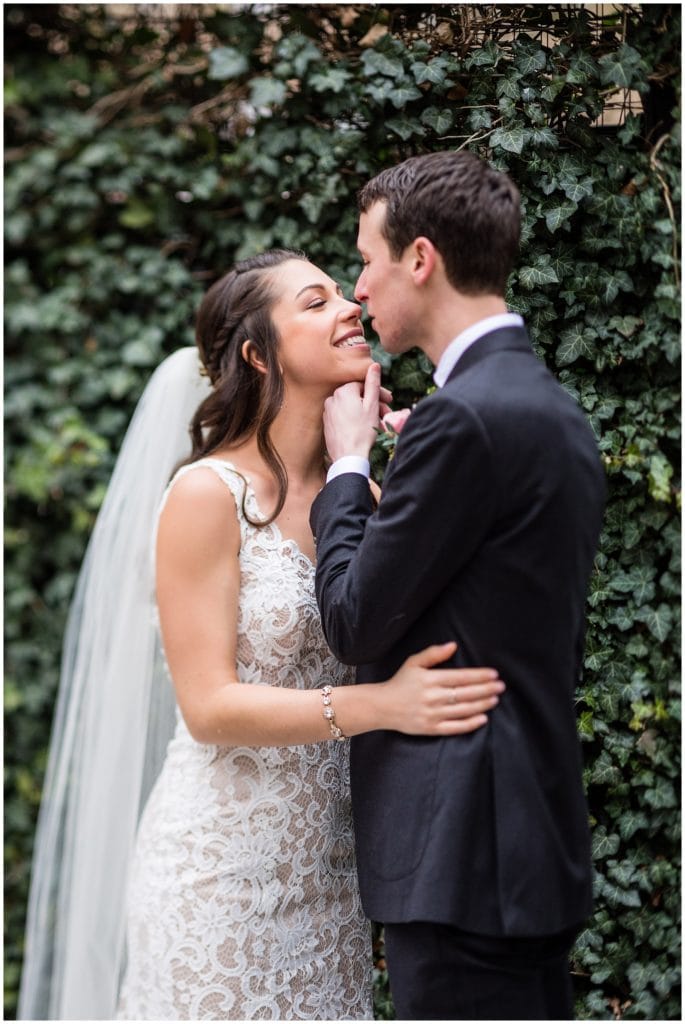 Groom lifting brides chin for a kiss in Rittenhouse Square Park