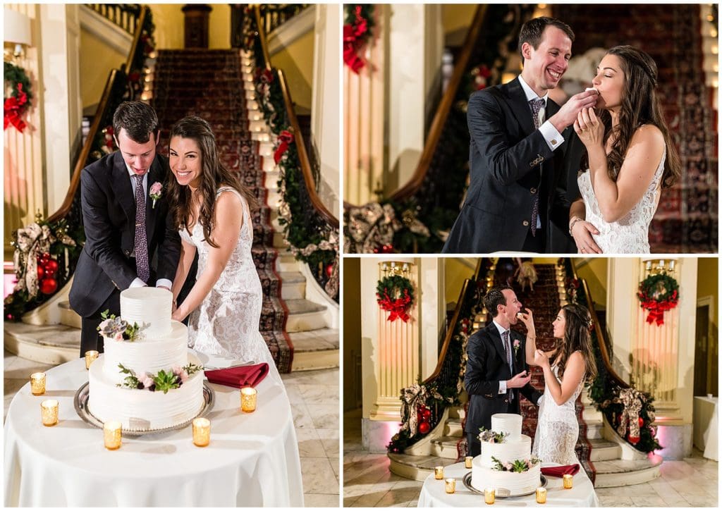 Bride and groom cut cake and feed each other cake at Racquet Club of Philadelphia winter holiday wedding reception
