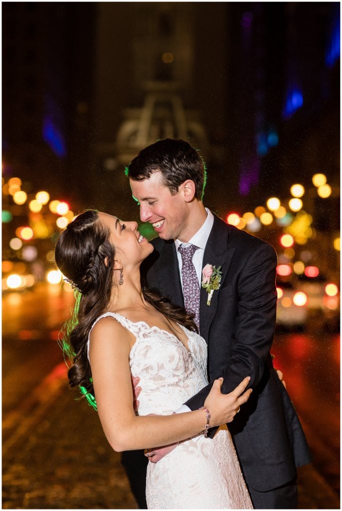 Groom dips bride in Broad Street night shot with green backlight at winter holiday wedding
