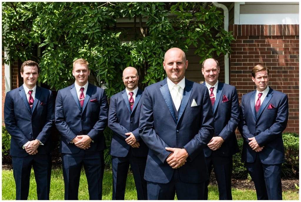 Traditional groomsmen portrait with groom standing in front