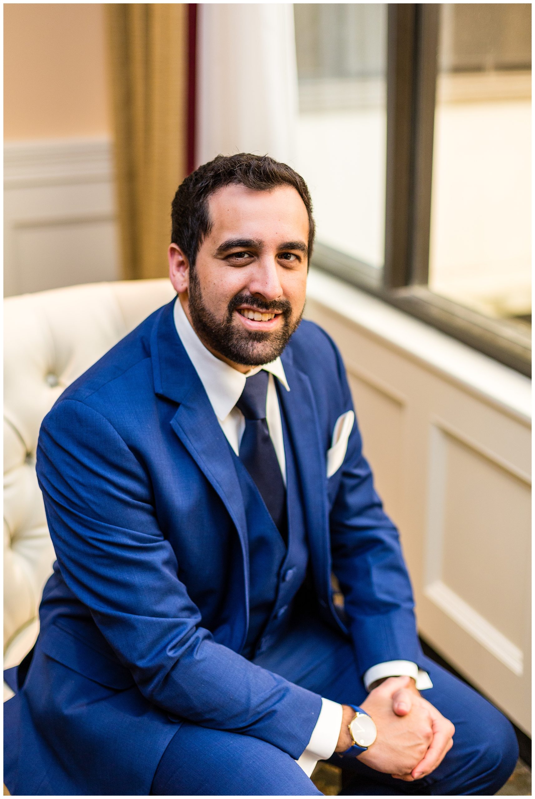 Traditional window lit groom sitting portrait at Radnor Hotel wedding