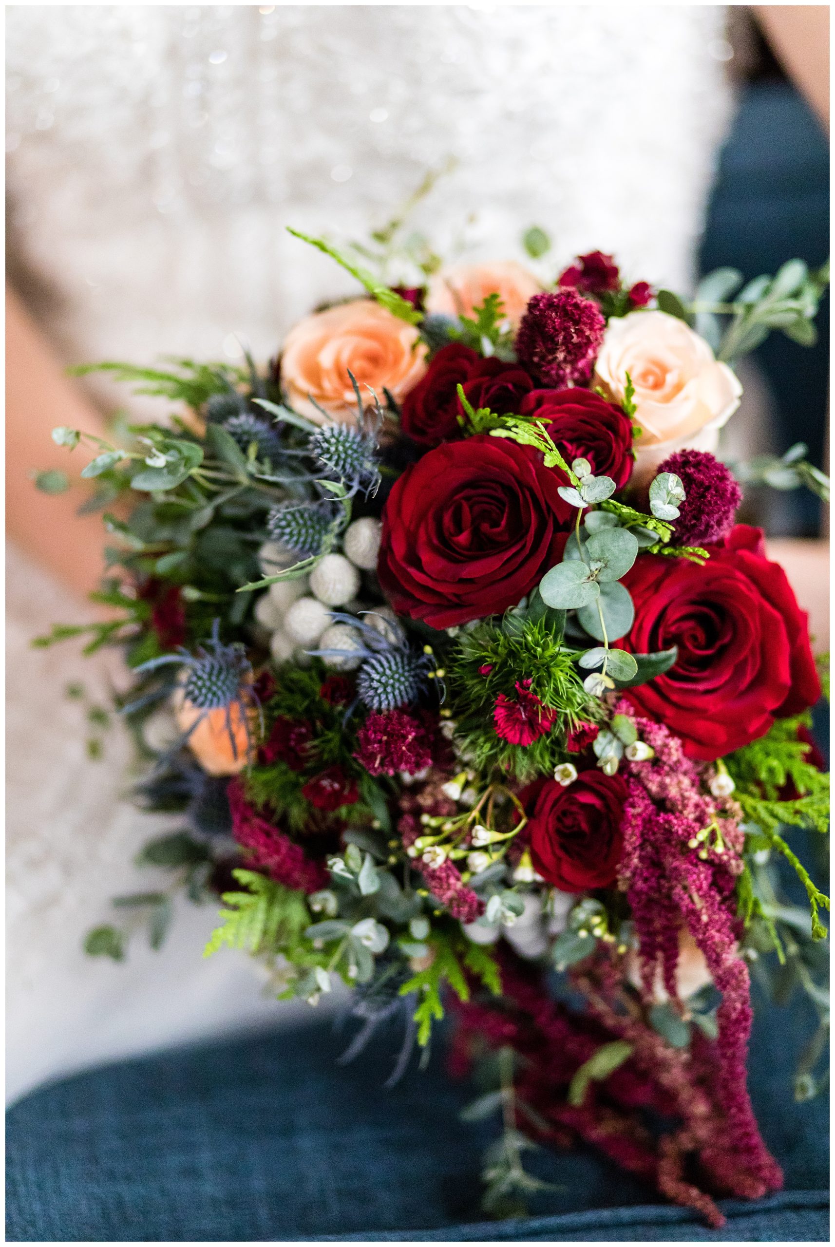 Colorful textured bridal bouquet with red roses