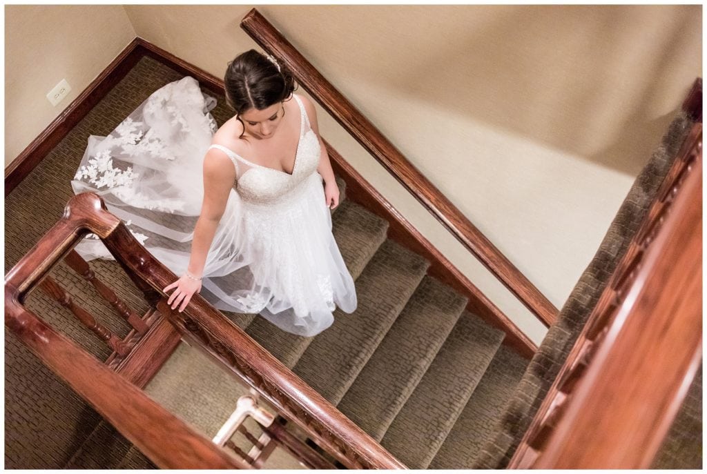 Bride walking down stairs to first look at Radnor Hotel wedding