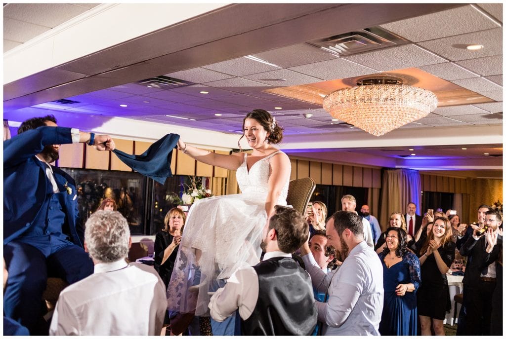 Bride and groom lifted on chairs during wedding reception at Radnor Hotel