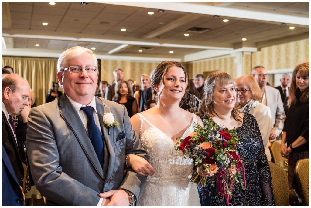 Bride and her parents walk down aisle at Radnor Hotel winter wedding ceremony