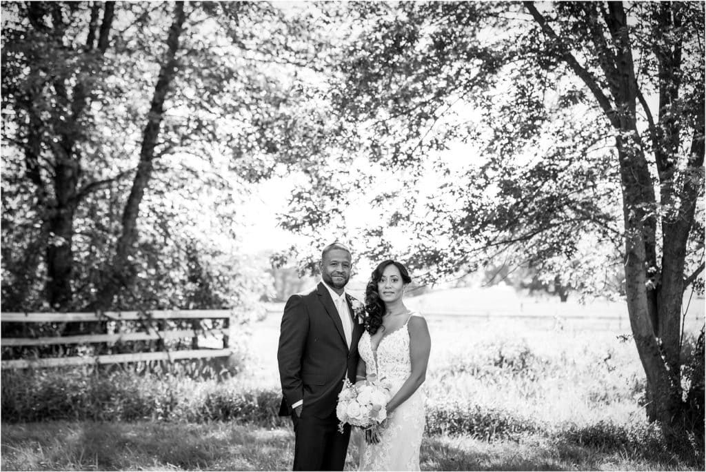 Black and white portrait of husband and wife in field at Barn at Stoneybrooke 25th wedding anniversary vow renewal