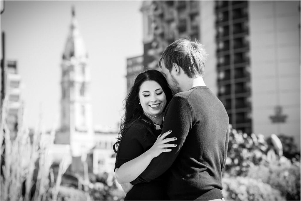 black and white portrait of man kissing fiancé on forehead in Center City Philadelphia engagement session