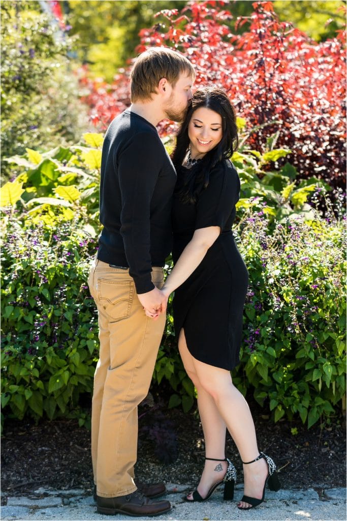 Traditional engagement session portrait of man kissing fiancés forehead in Center City Philadelphia park