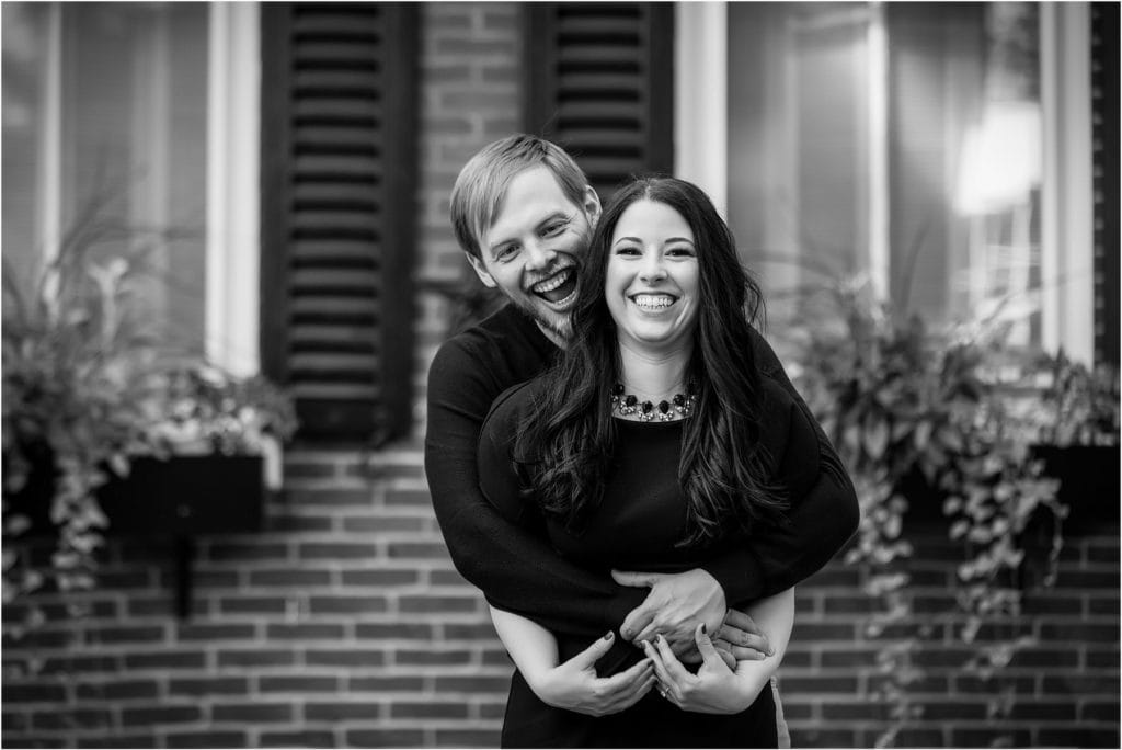 Black and white engagement session portrait of couple hugging and laughing in Center City Philadelphia