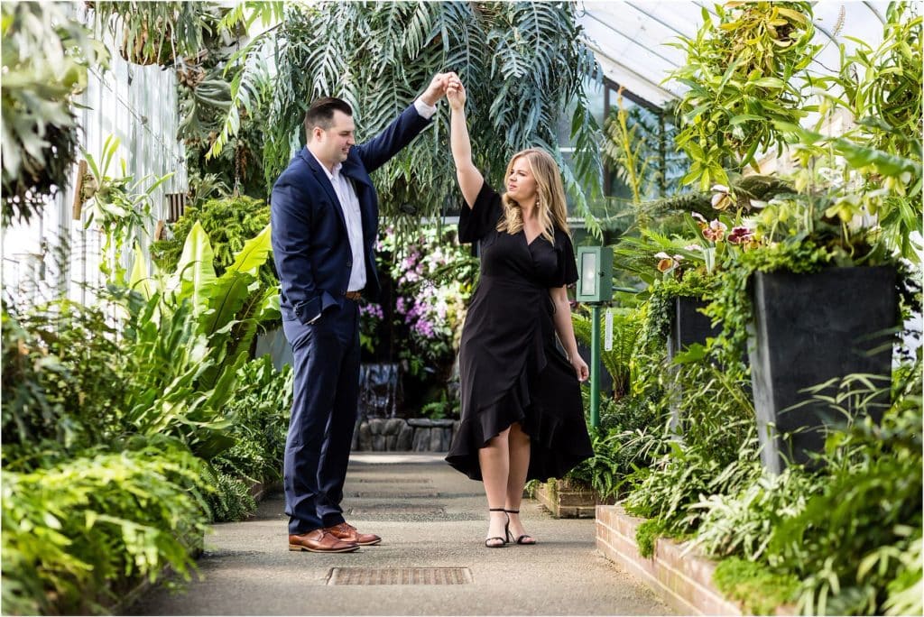 Groom spinning bride in greenhouse at Longwood Gardens engagement session