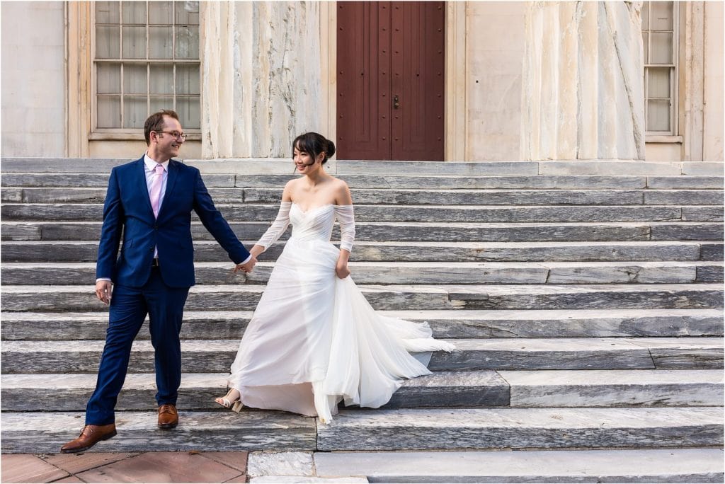 Groom leads bride down steps of First National Bank in Philadelphia intimate wedding
