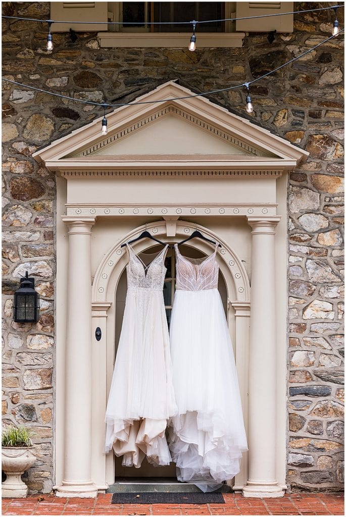 Brides' wedding gowns hanging together in doorway at Bolingbroke Mansion Same Sex Pride wedding