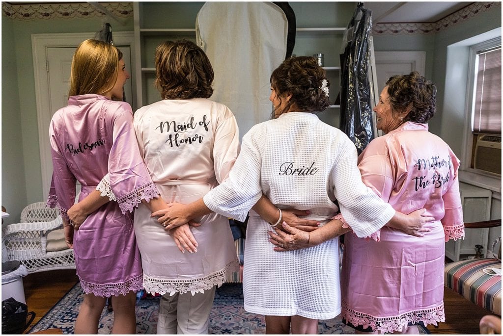 Bride, maid of honor, mother of bride, and bridesmaids in pink and white robes at Bolingbroke Mansion same sex wedding