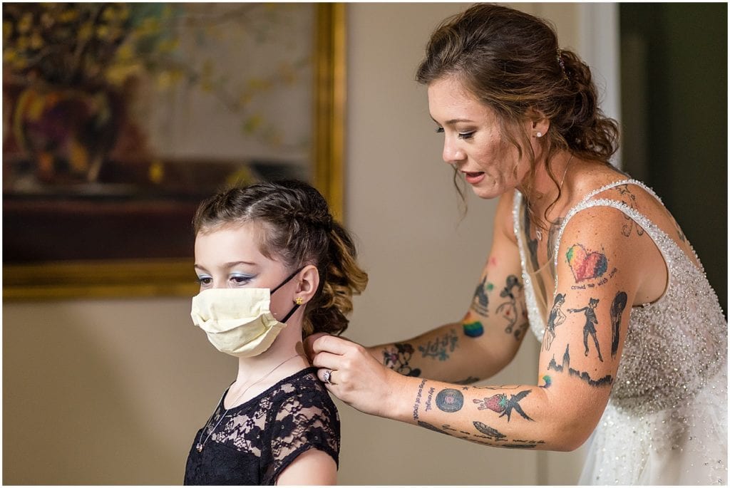Bride helping daughter put on necklace while getting ready for Bolingbroke Mansion same sex pride wedding