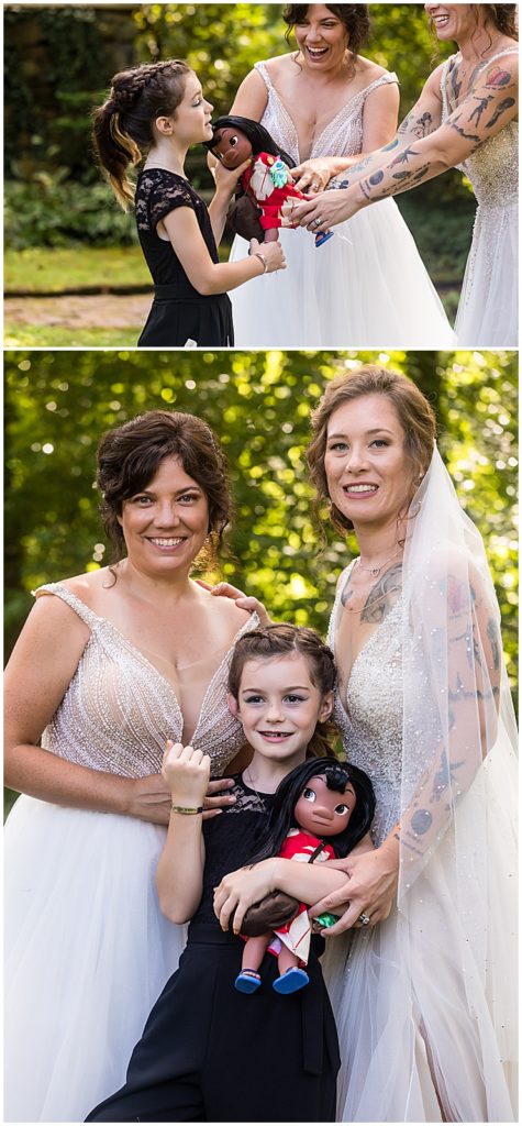 Brides and their daughter play with Moana doll at Bolingbroke Mansion same sex pride wedding reception