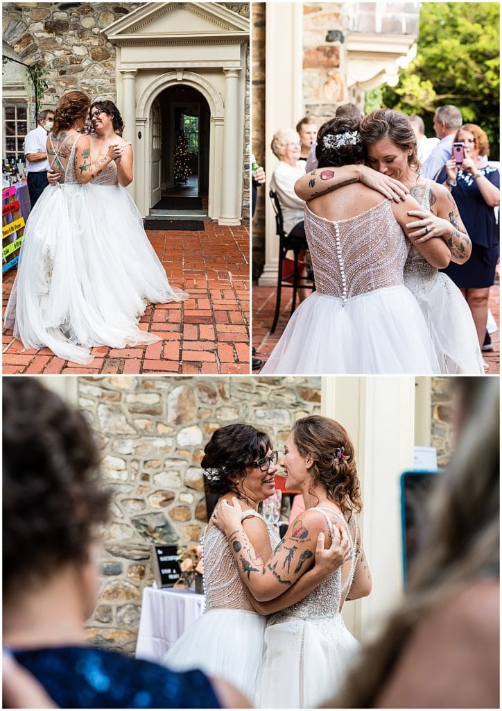 Brides smile at each other and hug during first dance at Bolingbroke Mansion same sex pride wedding reception