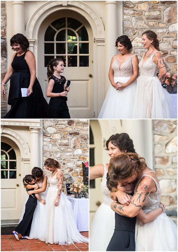 Brides listen to daughters toast and hug her collage at Bolingbroke Mansion pride wedding reception