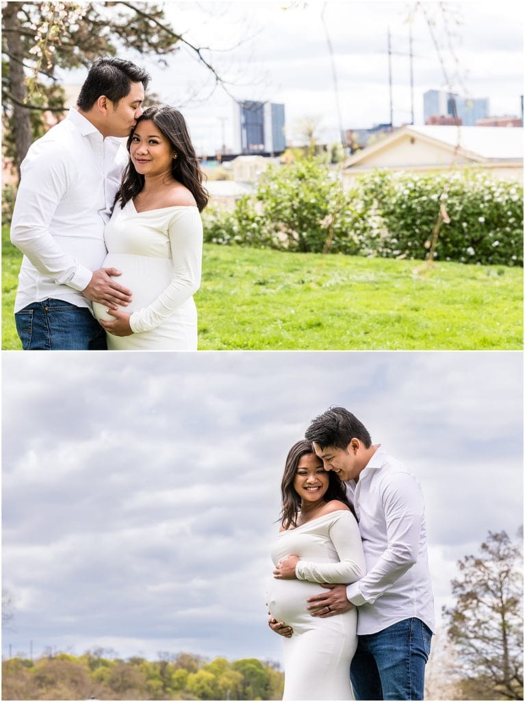 Husband holding pregnant wife's belly and kissing her forehead at their Philadelphia Art Museum maternity session