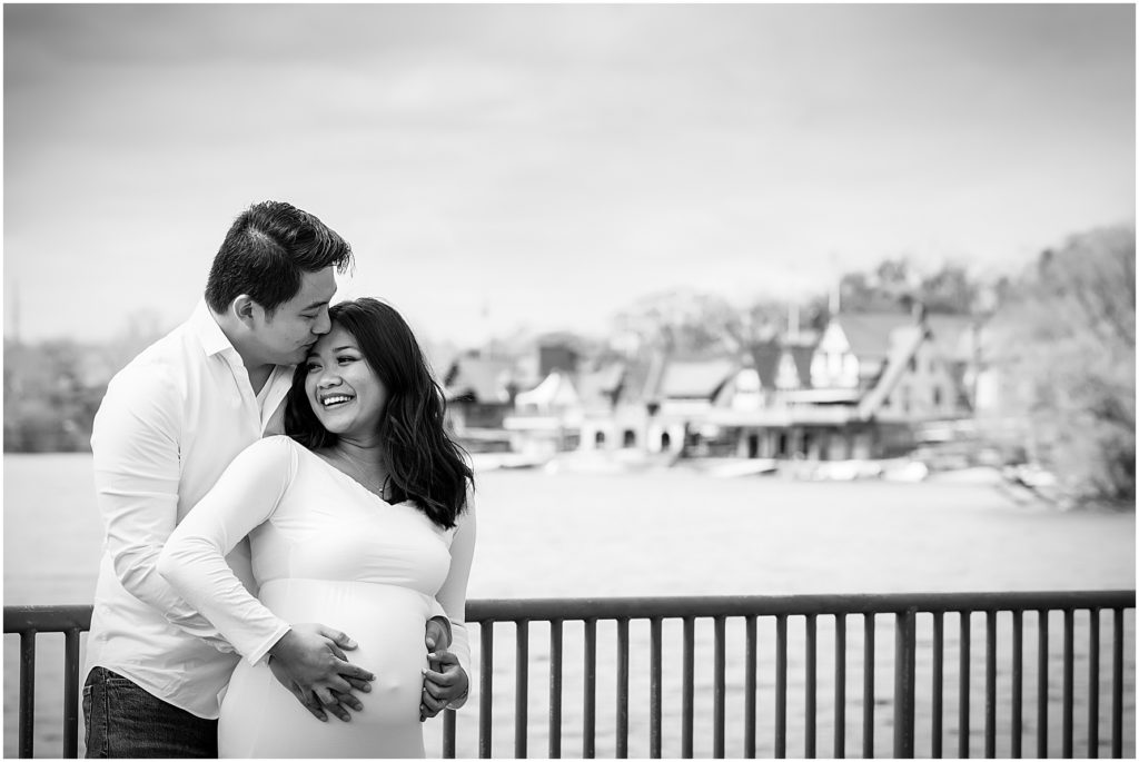 Black and white maternity couples portrait of husband and wife hugging in front of Boathouse Row at Philadelphia Museum of Art