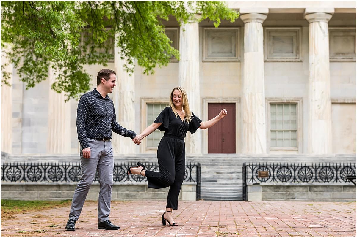 Couple strolling through Old City Philadelphia in front of the Second National Bank during engagement session