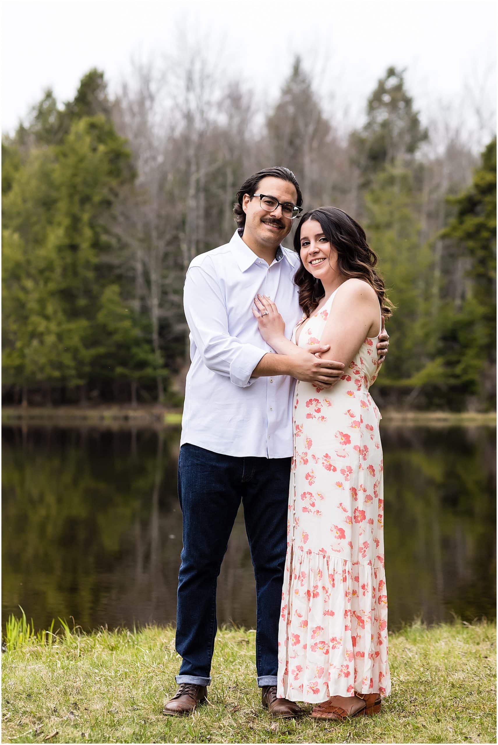 Pocono Mountains engagement session portrait of bride with hand on grooms chest in front of a lake