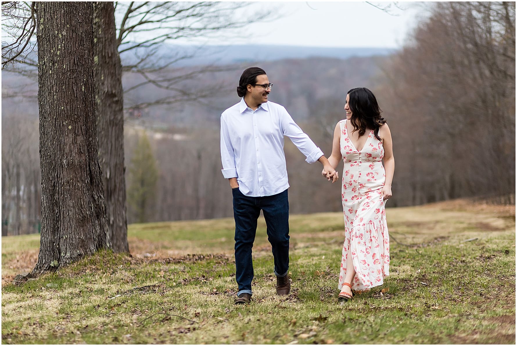 Couple holding hands and looking at each other while walking in the Pocono Mountains