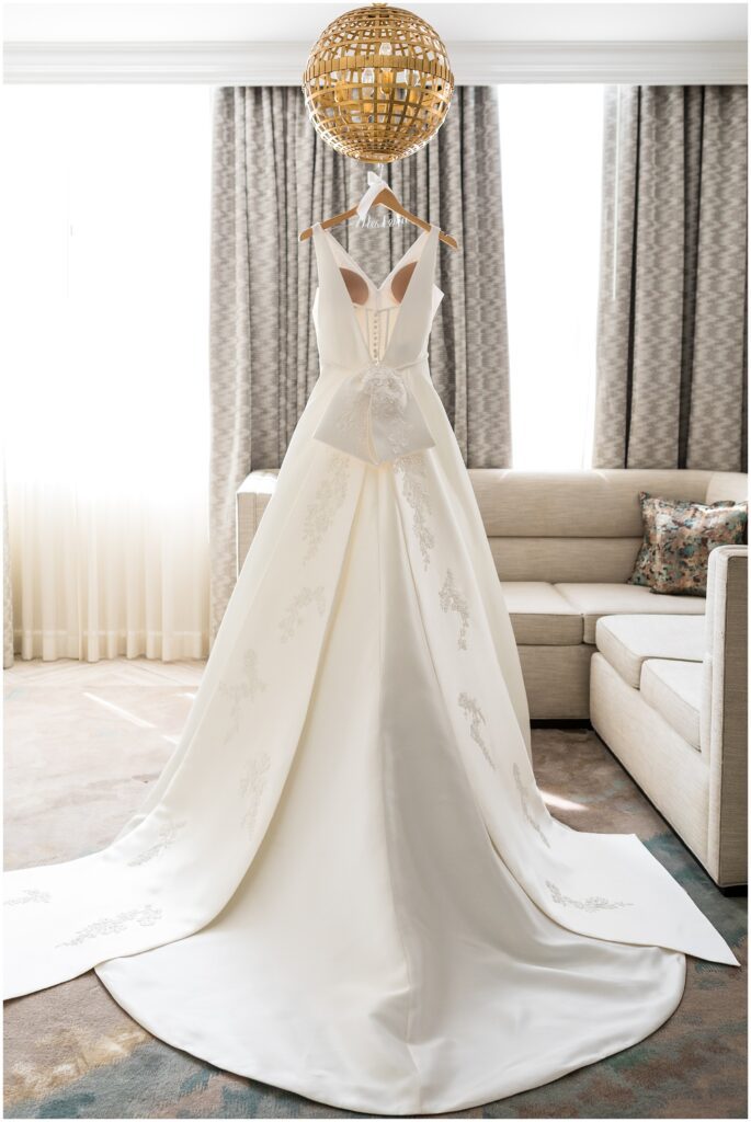 White wedding dress with large bow at the base of low v-back 