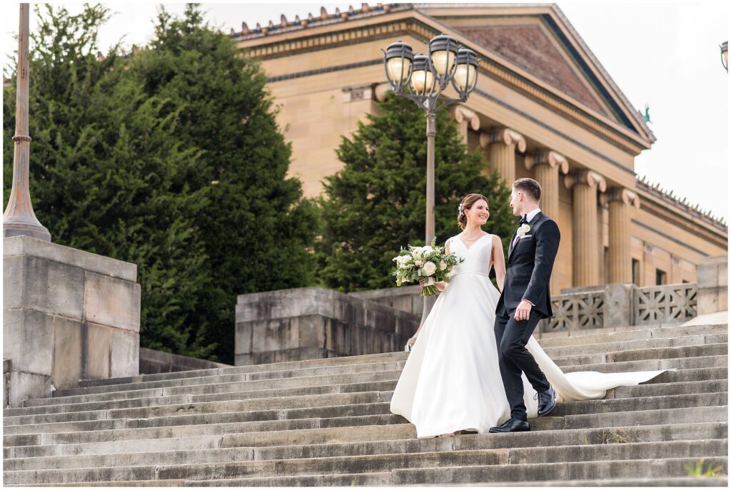 Bride and groom walk down the iconic Rocky stairs at the Philadelphia Museum of Art
