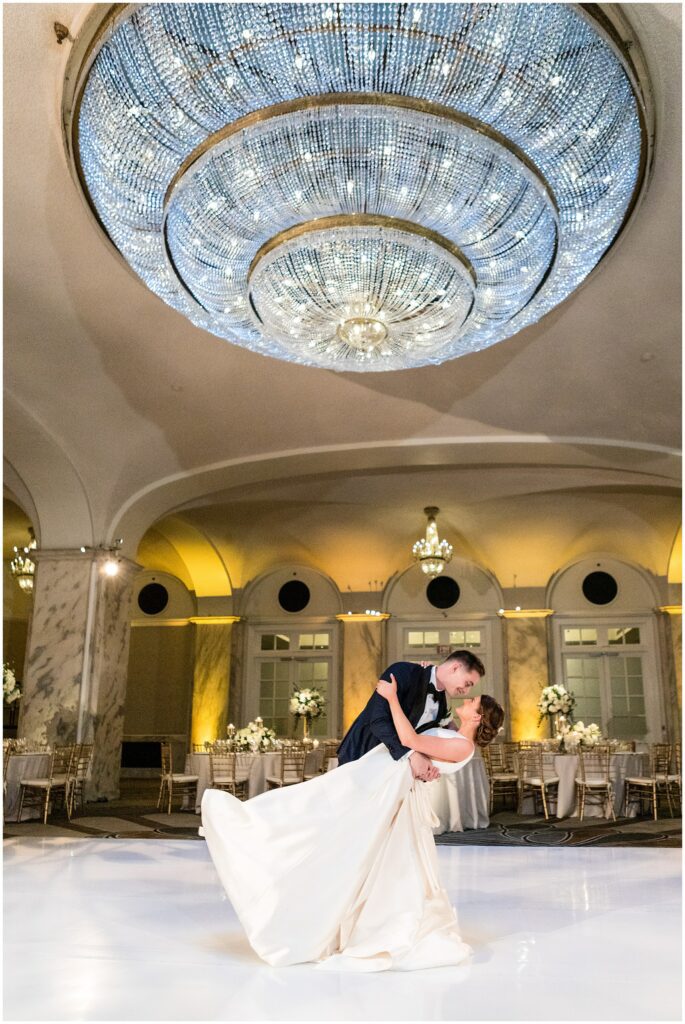 groom dips his bride on the white dance floor at Philadelphia Ritz-Carlton